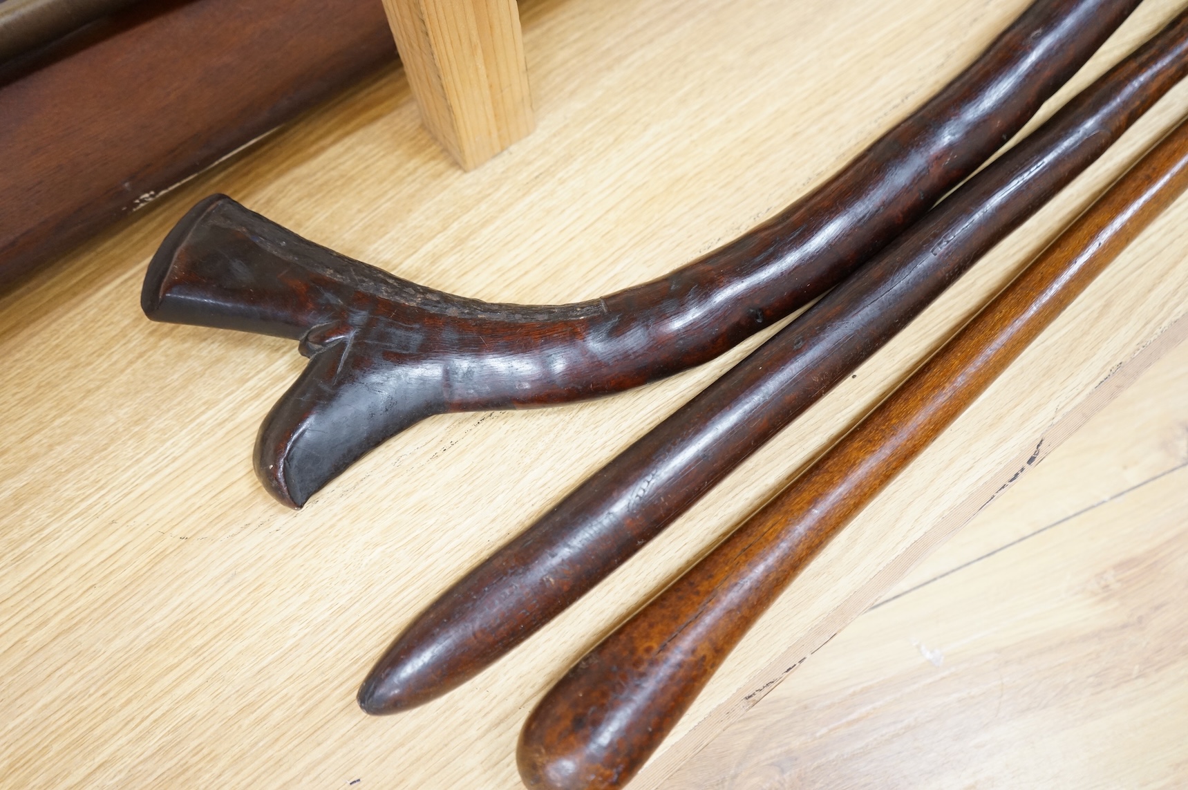 A Fiji hardwood club, probably 19th century or earlier, of gunstock form, overall length 89cm, together with a pole club, probably from Samoa, and a wooden walking stick (3)